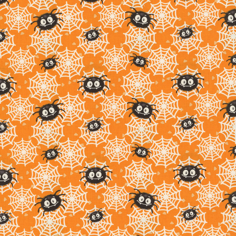 An orange fabric scattered with spiders and glow-in-the-dark spider webs. 