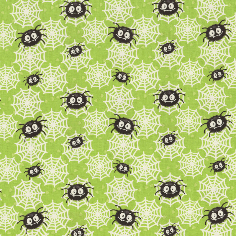 A green fabric scattered with spiders and glow-in-the-dark spider webs. 