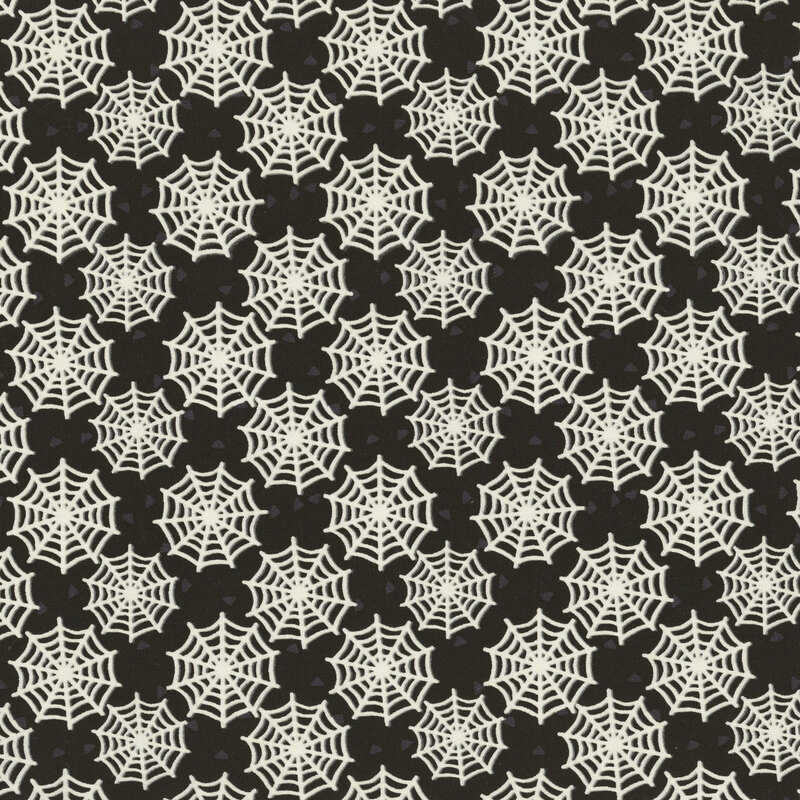 A black fabric scattered with glow-in-the-dark spider webs.