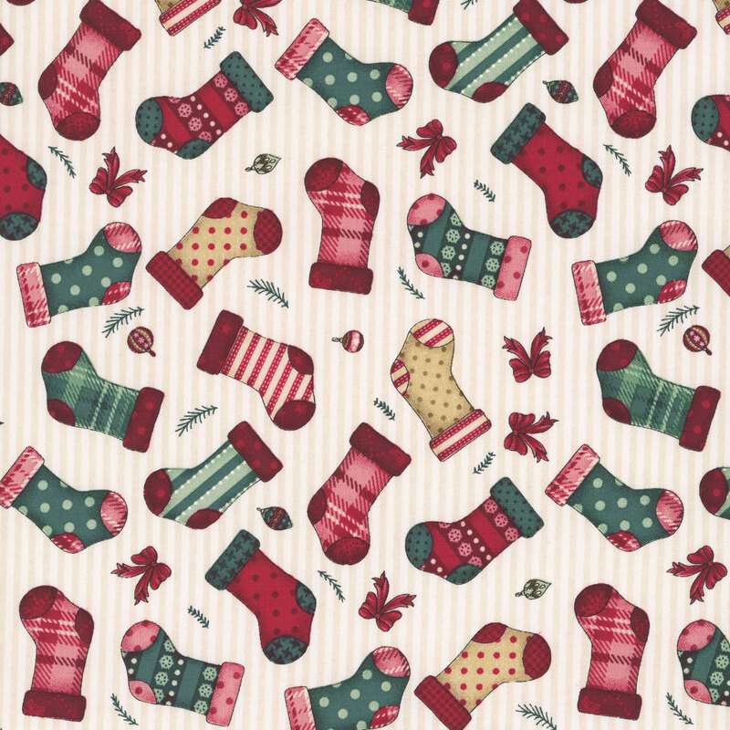 Patchwork stockings in red, tan, and green tossed with ribbons and ornaments on a white and cream stripped background.