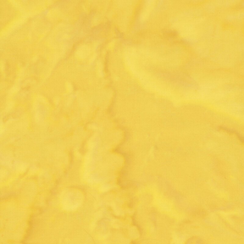 A mottled bright yellow watercolor batik fabric.