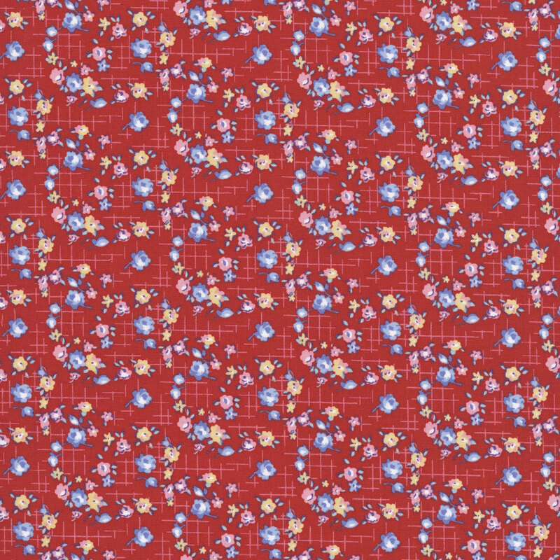 Red fabric with small blue, red, and yellow roses on a pink cross-hatched background.