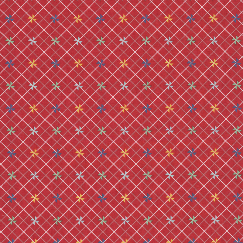 Red fabric with small colored pinwheels on a white and pink lattice background.