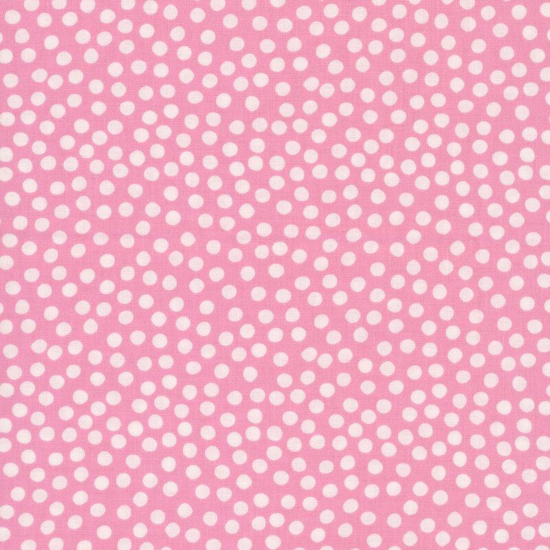 Dusty pink fabric with uneven white polka dots clustered together.