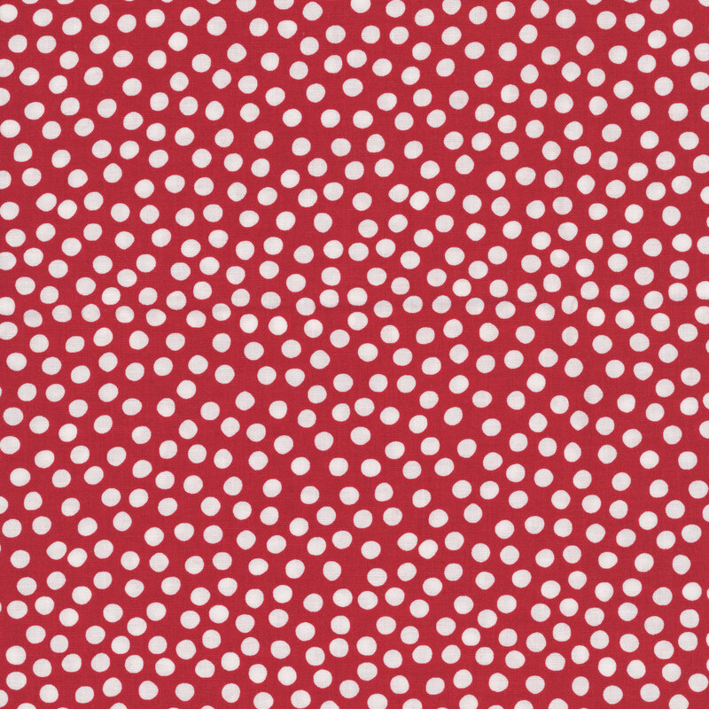 Dusty red fabric with uneven white polka dots clustered together.