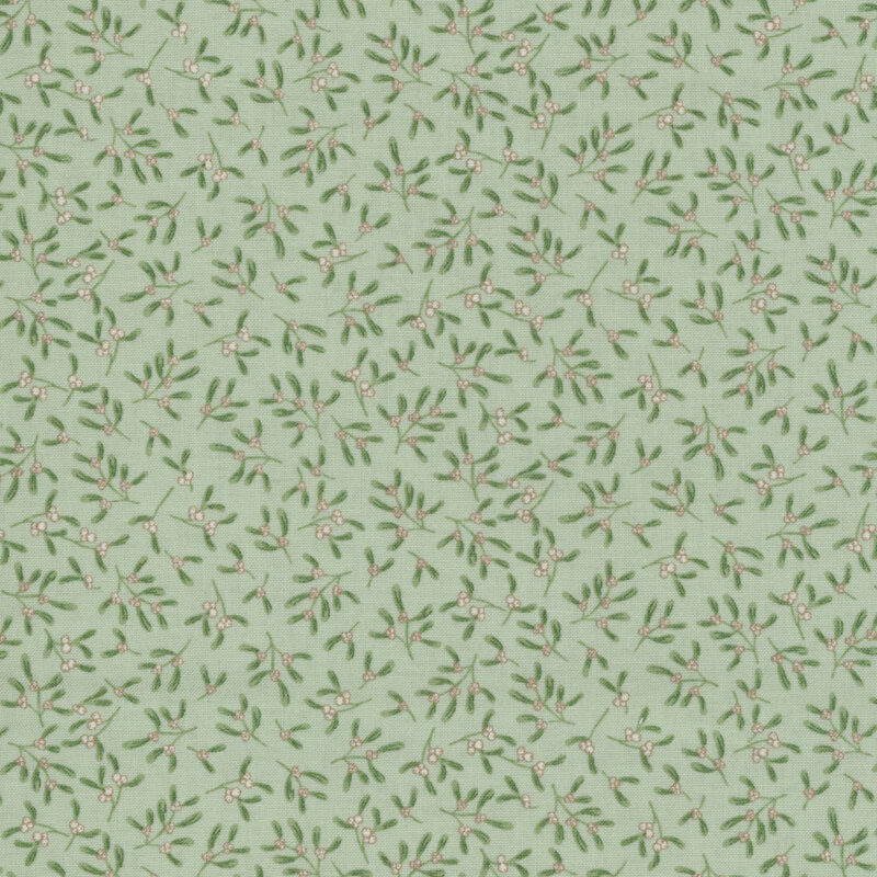 Sprigs of mistletoe tossed on green fabric.