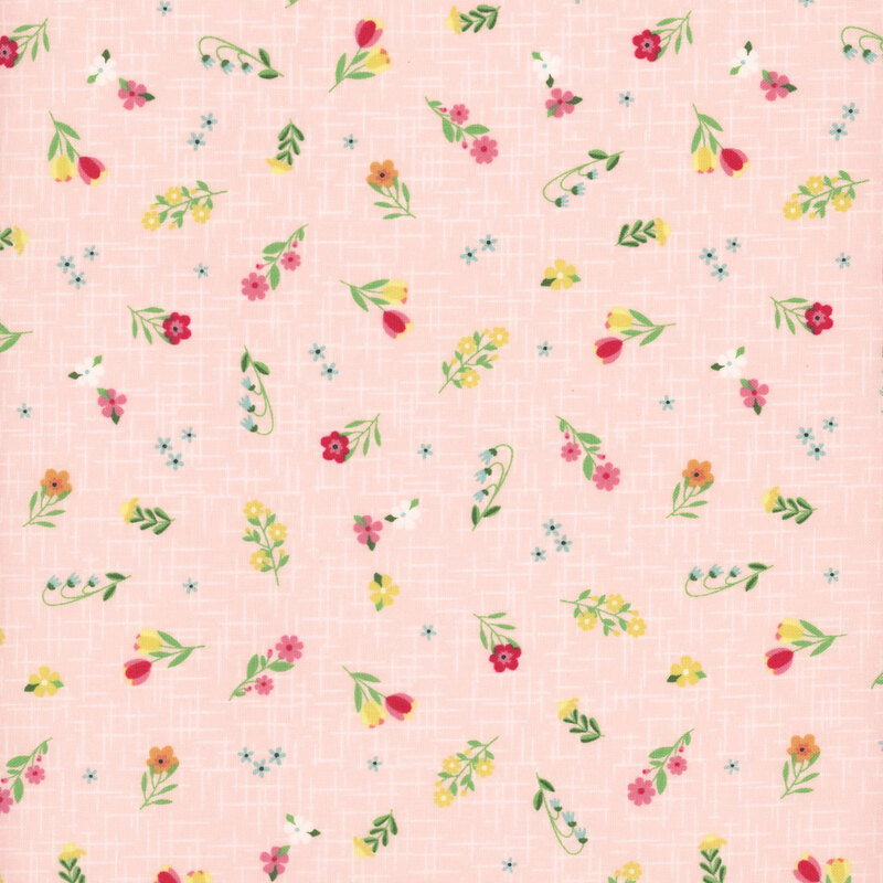 Soft pink fabric with a pattern of colorful summer florals accented by a subtle textured background.