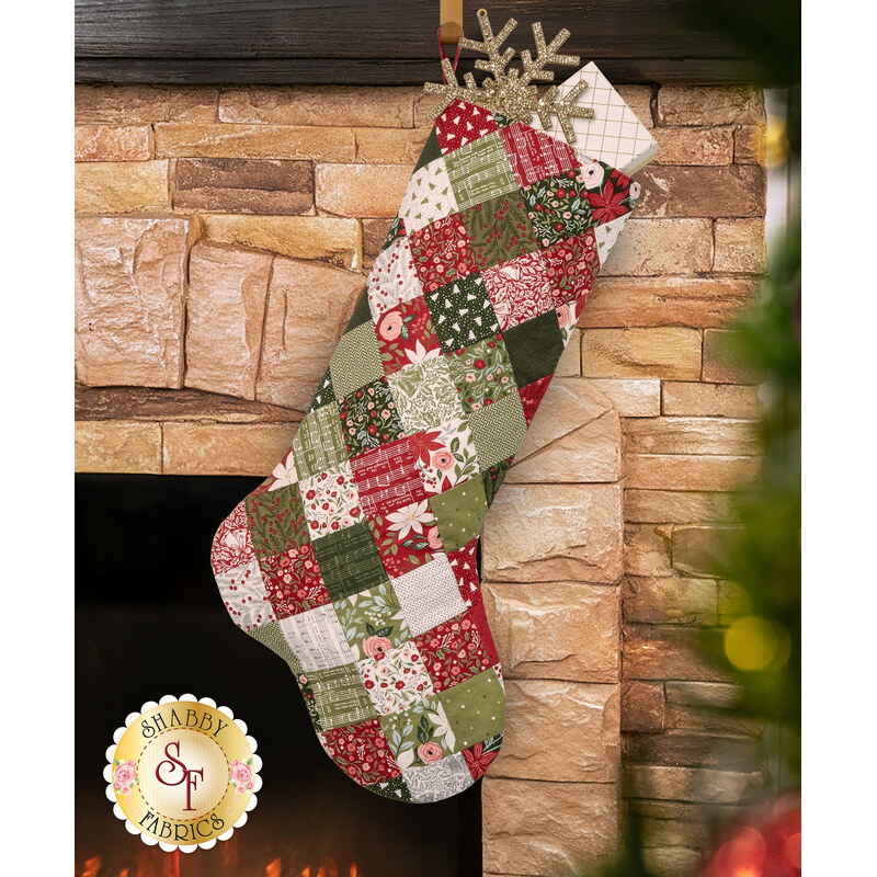 The completed Fast Fusible Patchwork Stocking colored in the Berry & Pine collection by Moda Fabrics, hung on a stone fireplace with Christmas decor and gifts peeking out of the top of the stocking.