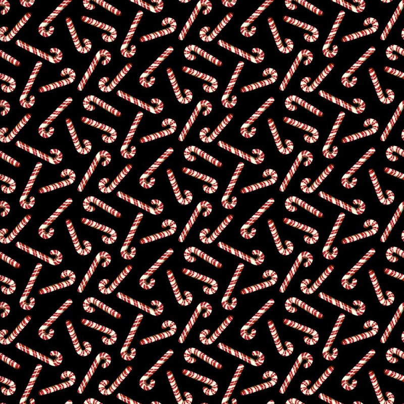 Red and white candy canes tossed on black fabric.