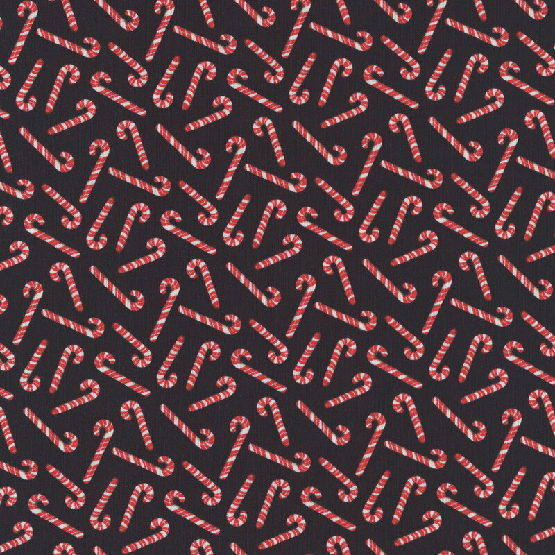 Red and white candy canes tossed on black fabric.