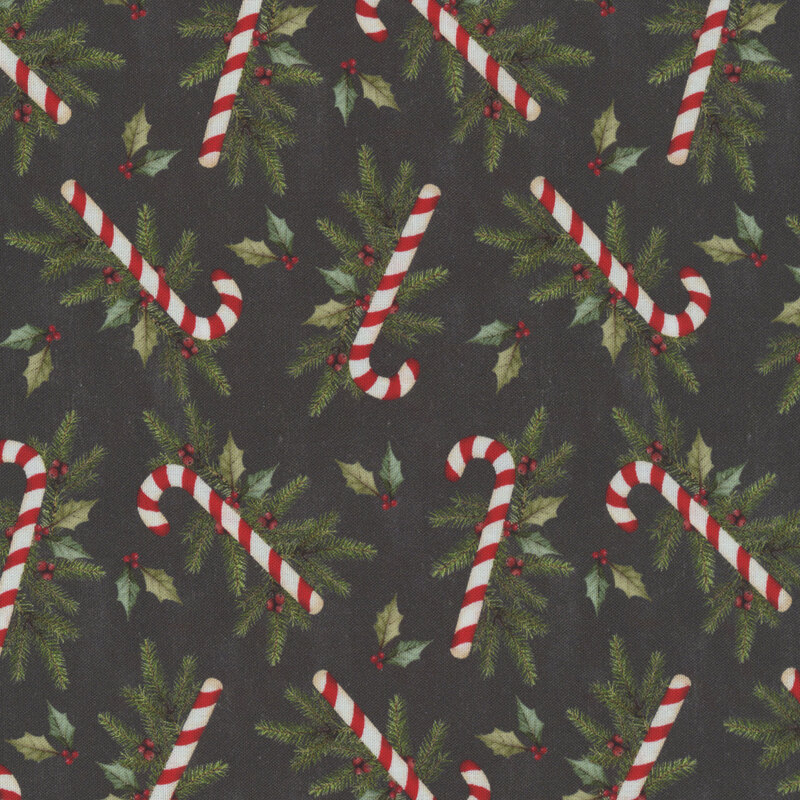 Scattered candy canes with green holly leaves and red berries on a mottled charcoal gray background