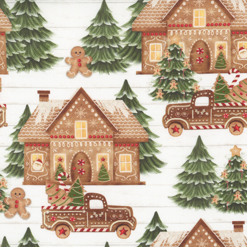 White shiplap background with evergreen trees and gingerbread men outside gingerbread homes with gingerbread trucks