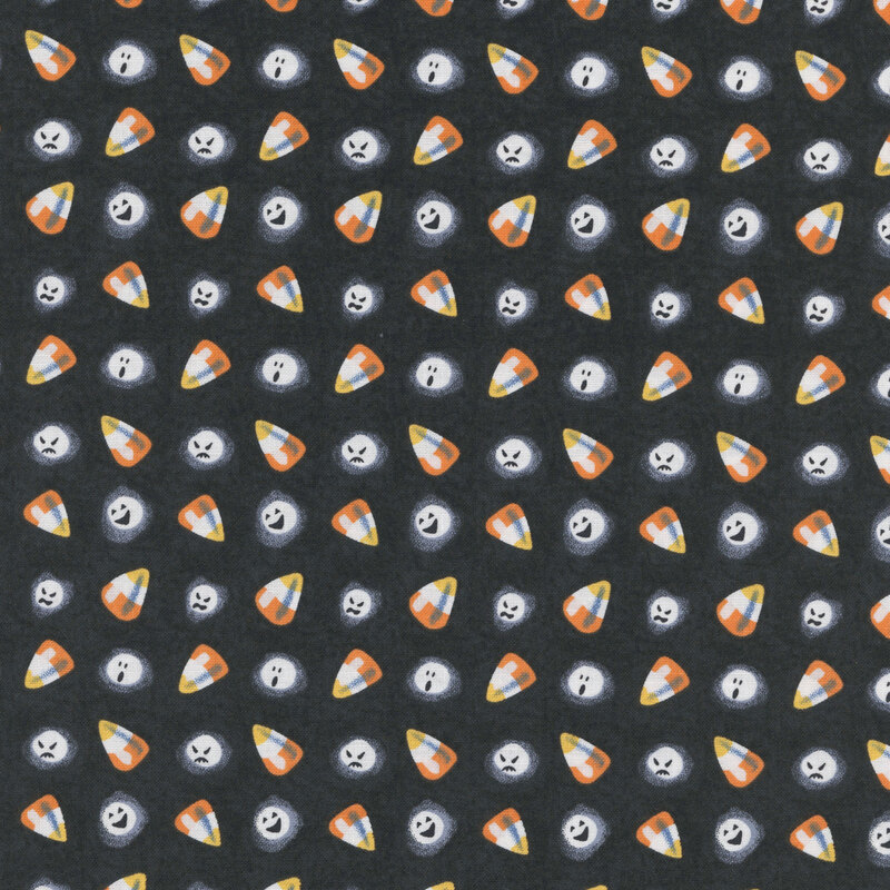 Candy corn and ghostly white faces tossed on black fabric