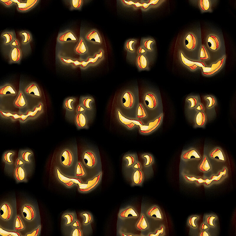Illuminated jack-o'-lantern faces carved into black fabric.