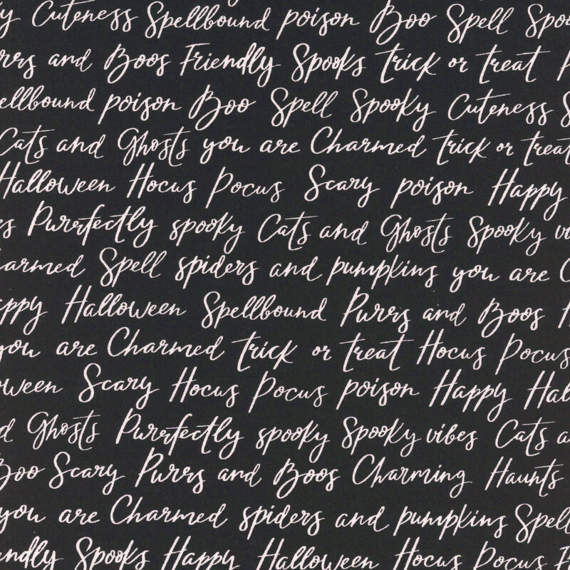 Black fabric with rows of Halloween-themed words and phrases in cursive script.