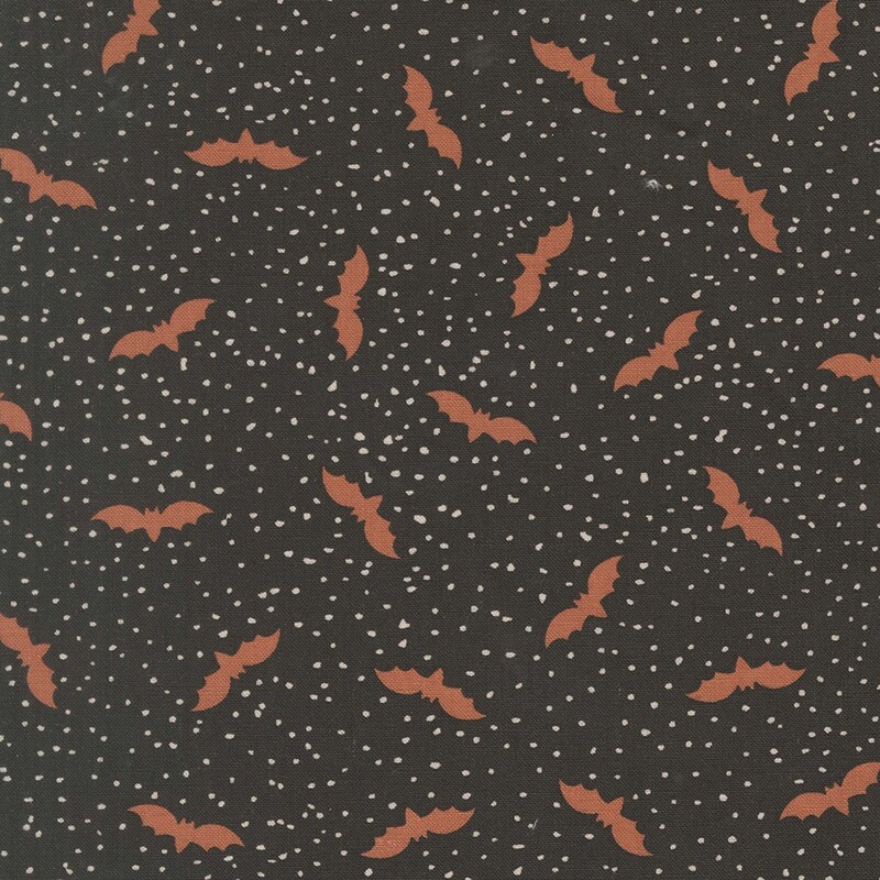 Black fabric with tiny scattered cream dots and flying bats.