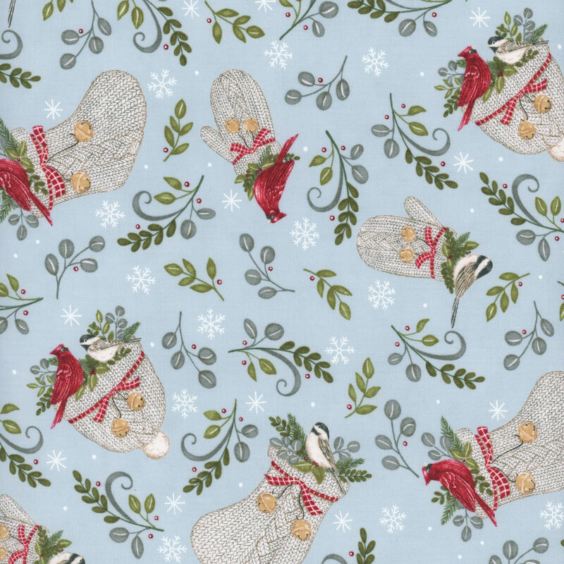 Light beige knitted hats and gloves scattered with green leaves, finches, and cardinals, on sky blue fabric