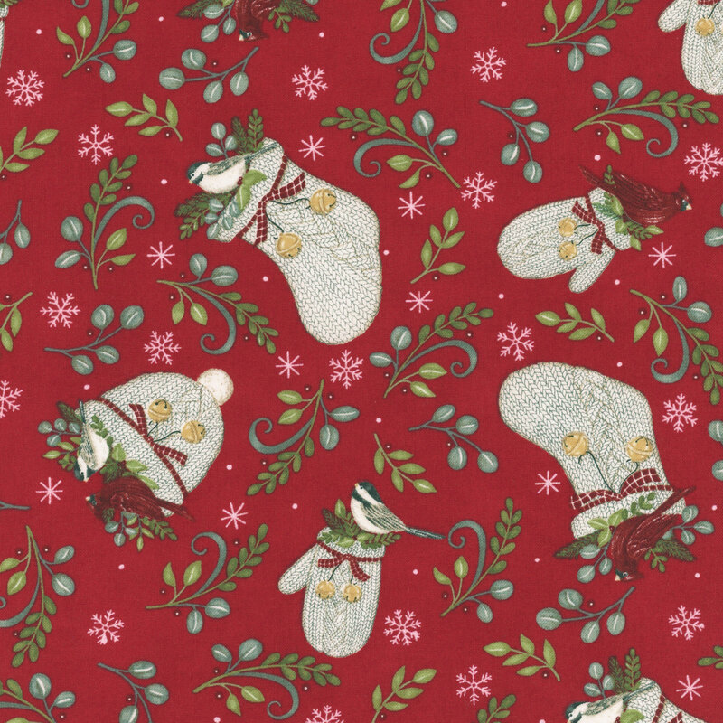 Light beige knitted hats and gloves scattered with green leaves, finches, and cardinals, on crimson fabric