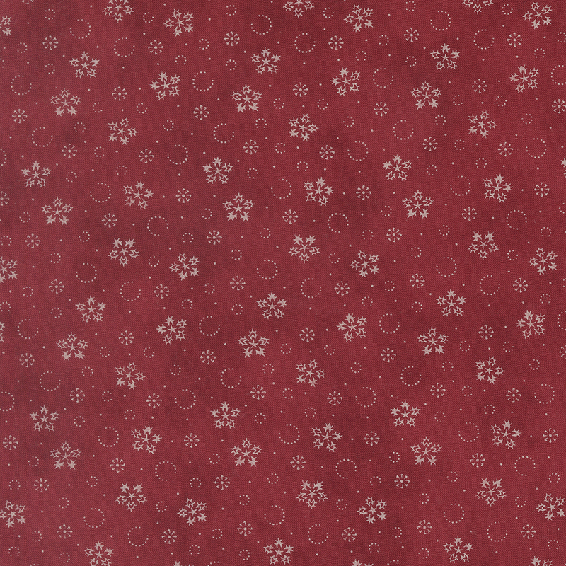 Mottled red fabric with a pattern of stylized snowflakes and tiny pindots.