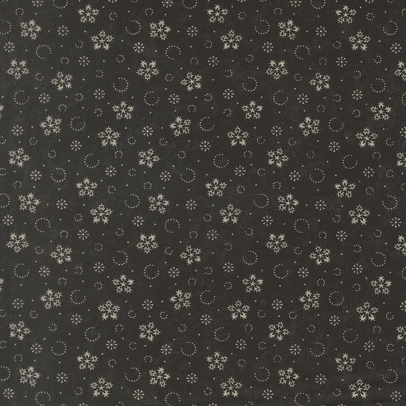 Mottled black fabric with a pattern of stylized snowflakes and tiny pindots.