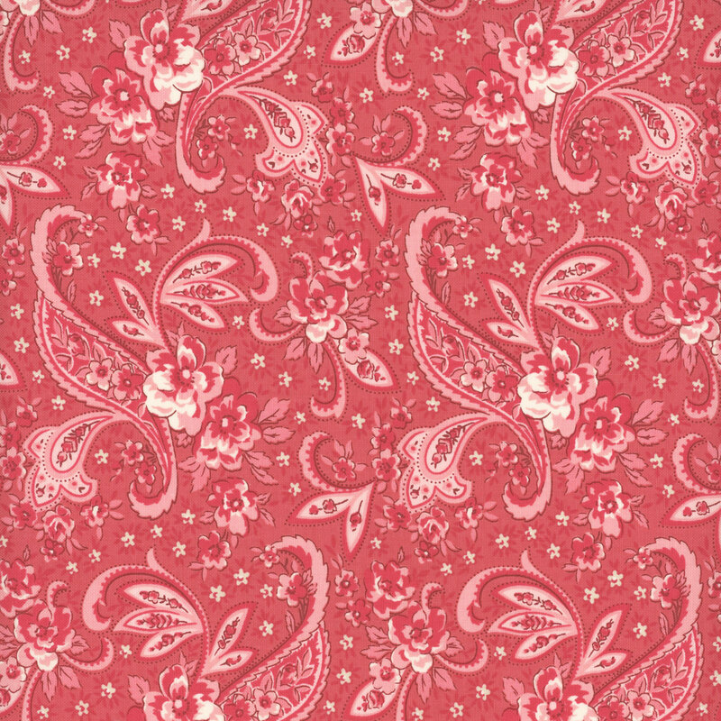 A salmon pink fabric with a light and dark pink floral paisley design with small sage green flowers.