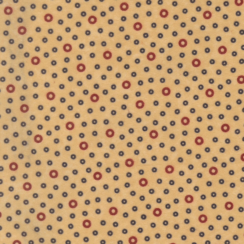 Flannel fabric featuring dark red and smaller blue rings tossed on a tan background.