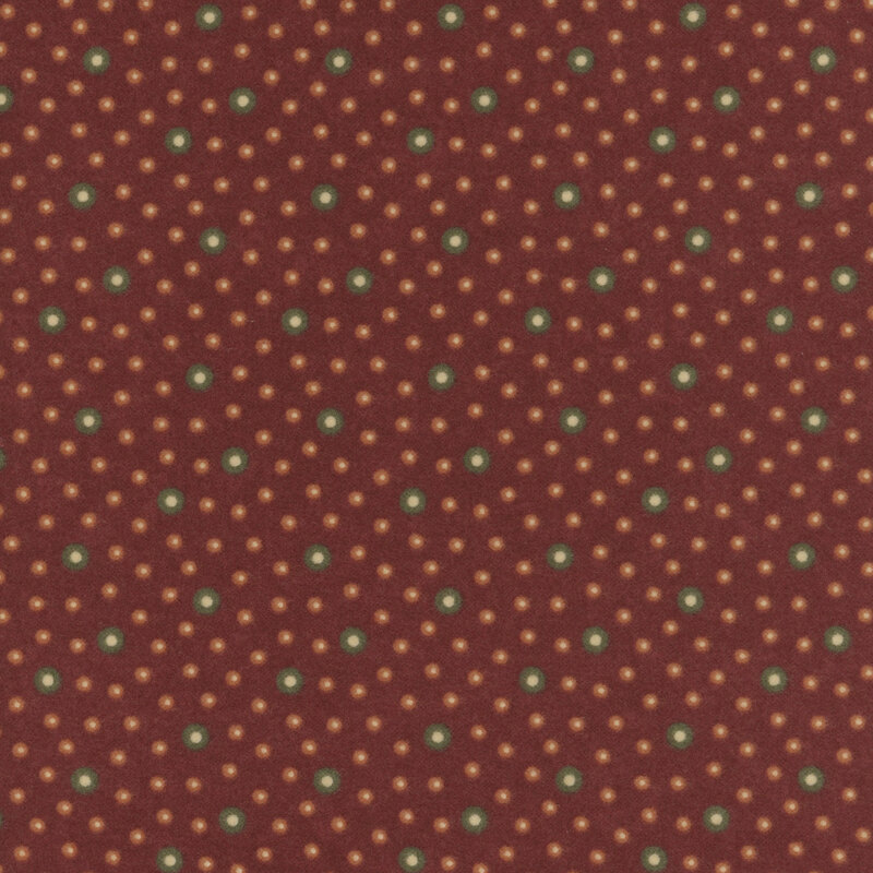 Flannel fabric featuring brown and orange rings with tan centers tossed on a dark red background.