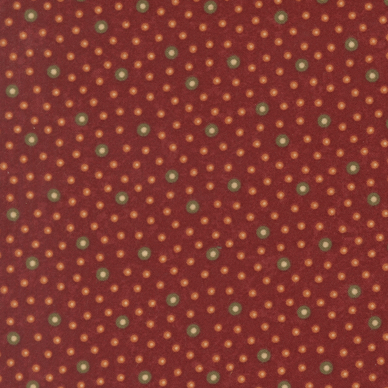 Flannel fabric featuring brown and orange rings with tan centers tossed on a dark red background.