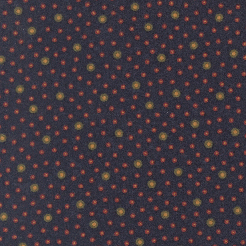Flannel fabric featuring brown and red rings with tan centers tossed on a navy blue background.