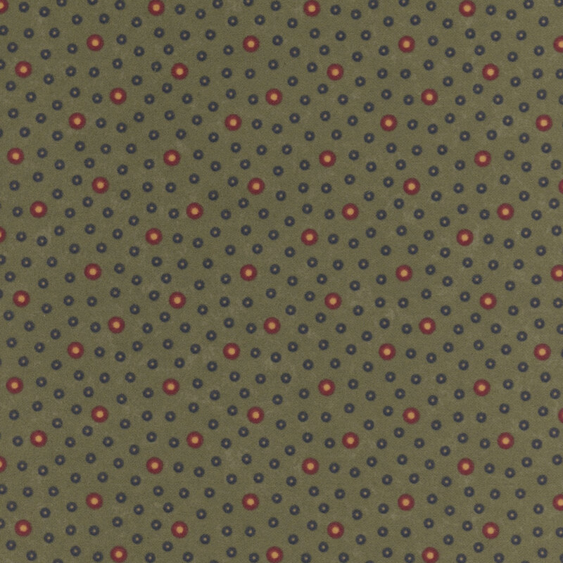 Flannel fabric featuring red and navy rings with tan centers tossed on a muted dark green background.