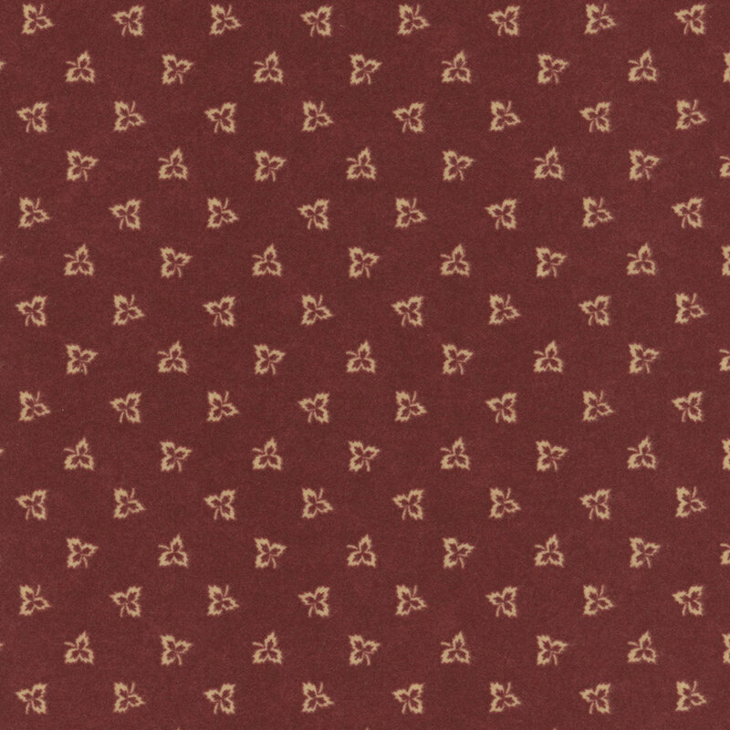 Maple leaf outlines tossed on dark red flannel fabric.