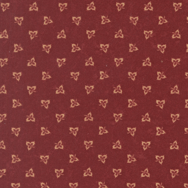 Maple leaf outlines tossed on dark red flannel fabric.