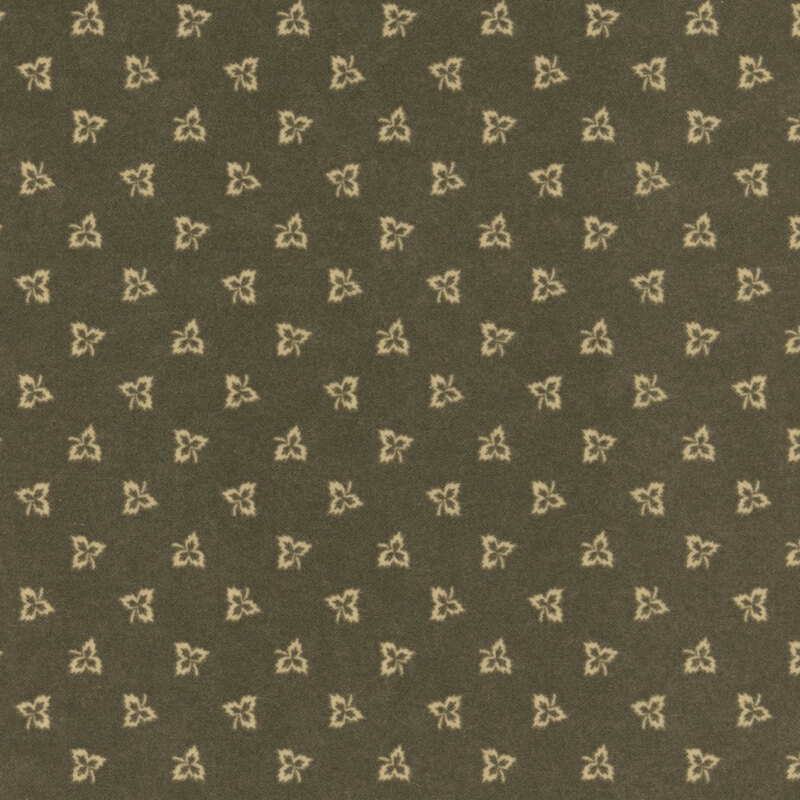 Maple leaf outlines tossed on dark olive green flannel fabric.