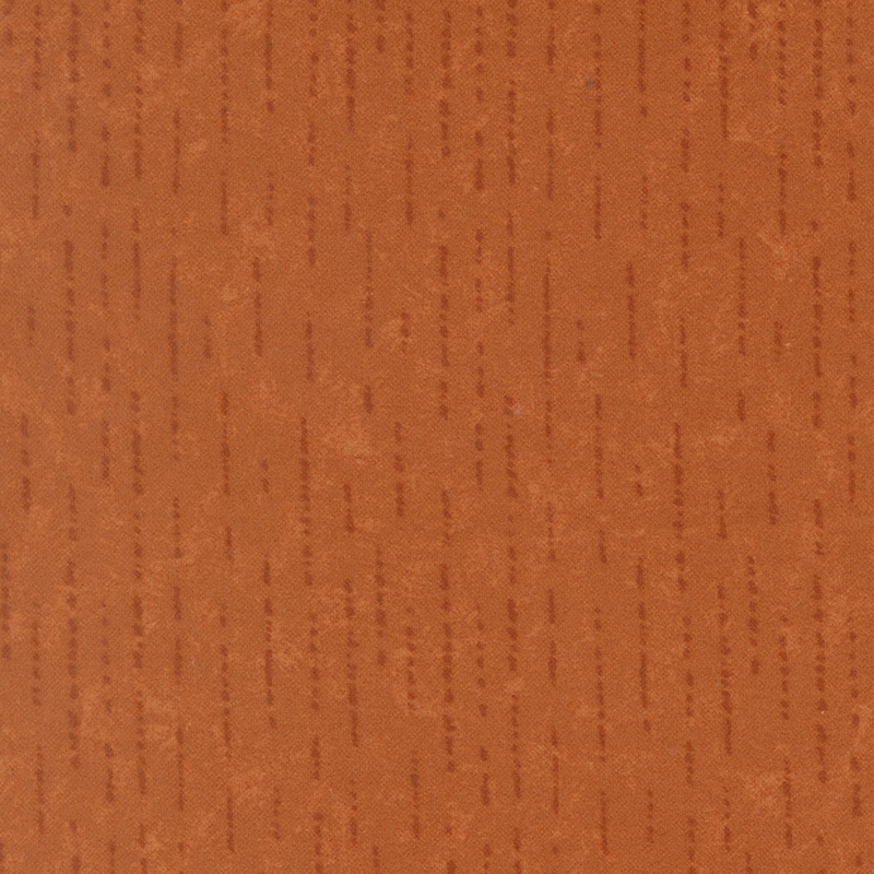 Tonal dark orange flannel fabric with dashed and dotted lines.