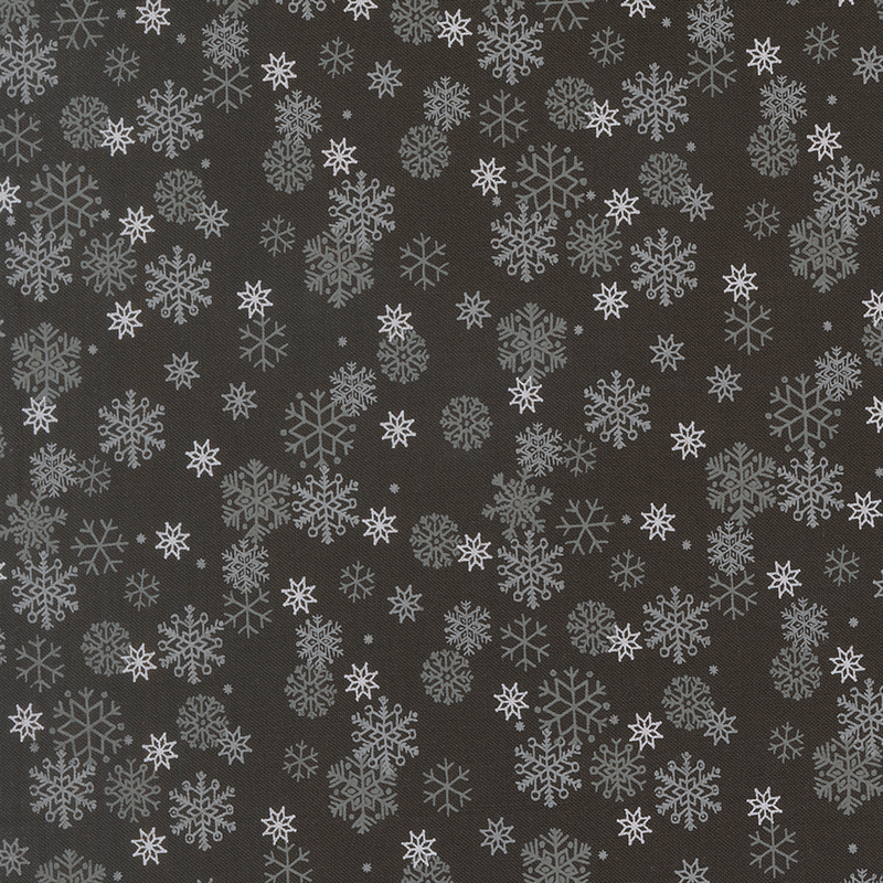 White and gray snowflakes tossed on a soft black background.