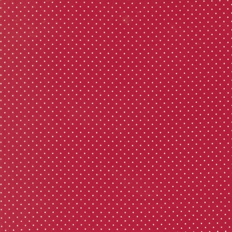 Cranberry red fabric with a delicate pattern of white pin dots