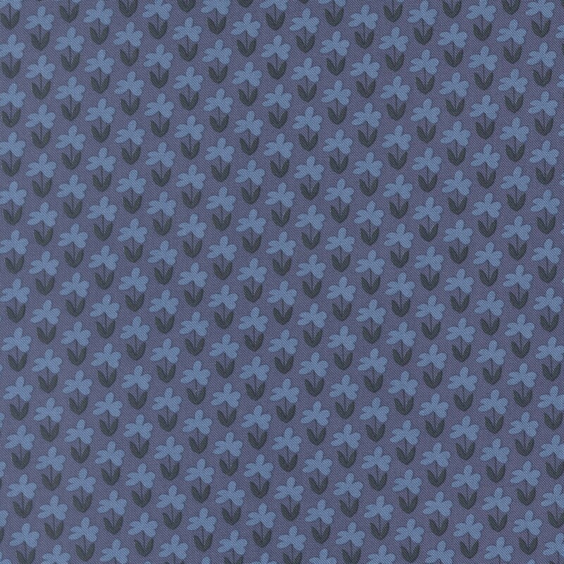 Denim blue fabric with a pattern of little cornflower blue florals and indigo stems