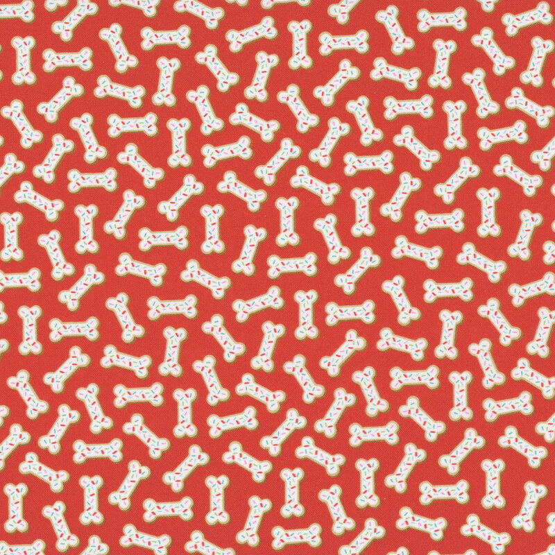 Scarlet fabric with dog bone shaped cookies with white frosting and rainbow sprinkles