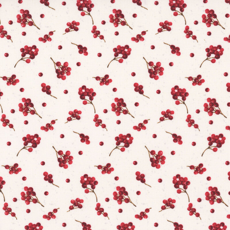 Sprigs of holly berries tossed on a light cream background.