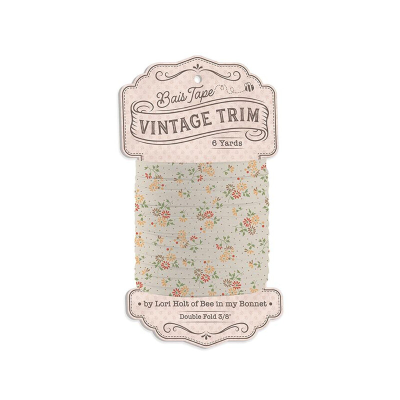 Spool of light beige with flowers and brown pin-dot bias tape isolated on a white background