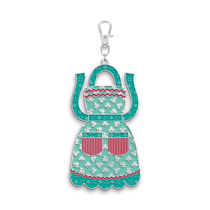 Silver keychain charm shaped like a teal kitchen apron with white flowers and red striped pockets on a white background.