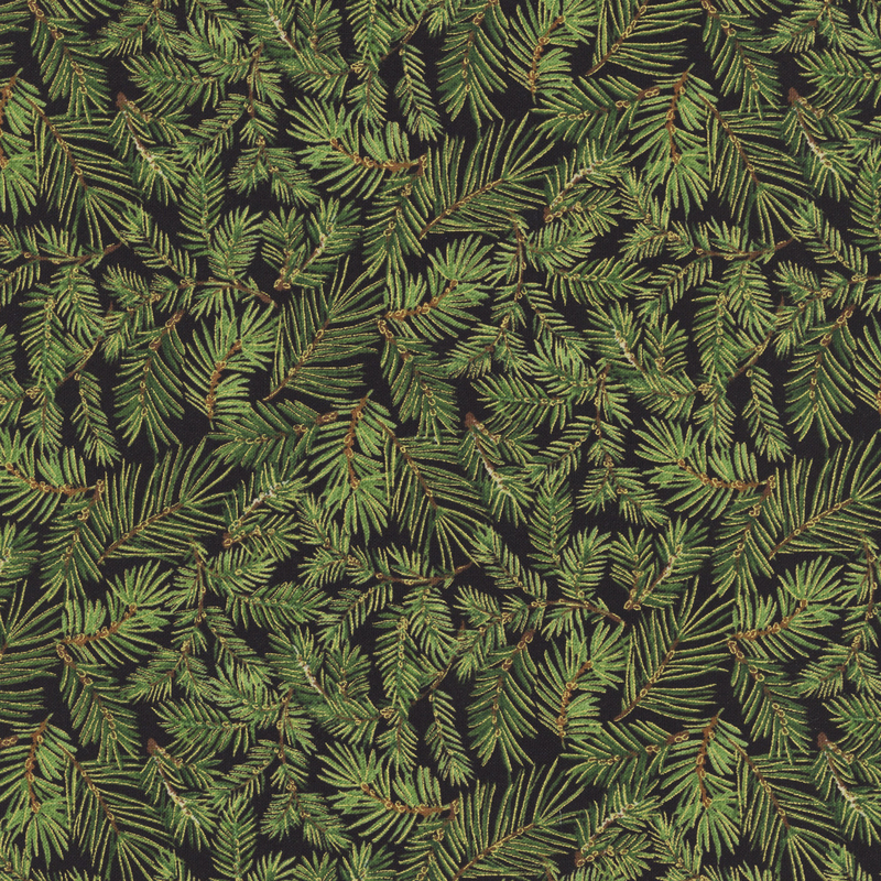 Green pine branches with gold metallic accents tossed on a black background.