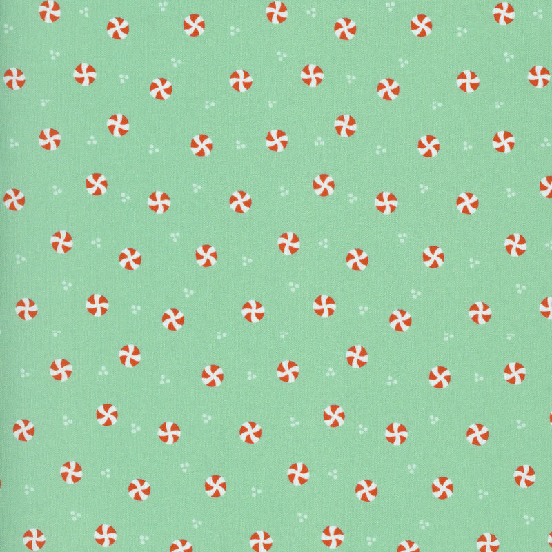 Mint green fabric with a ditsy pattern of white dots and red and white peppermints