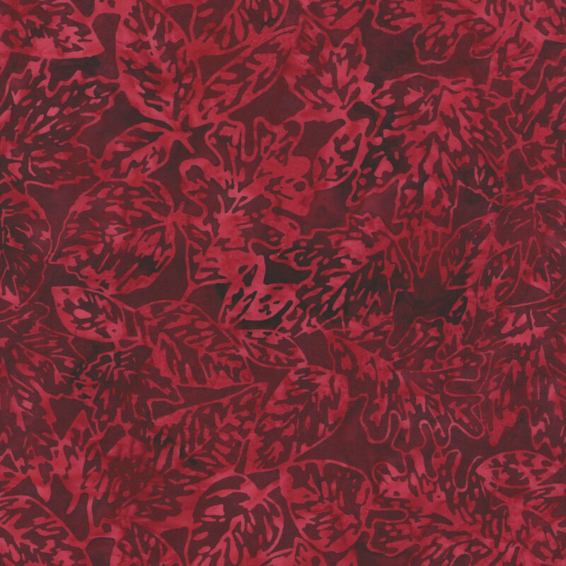 A tonal dark red batik fabric with scattered leaves. 