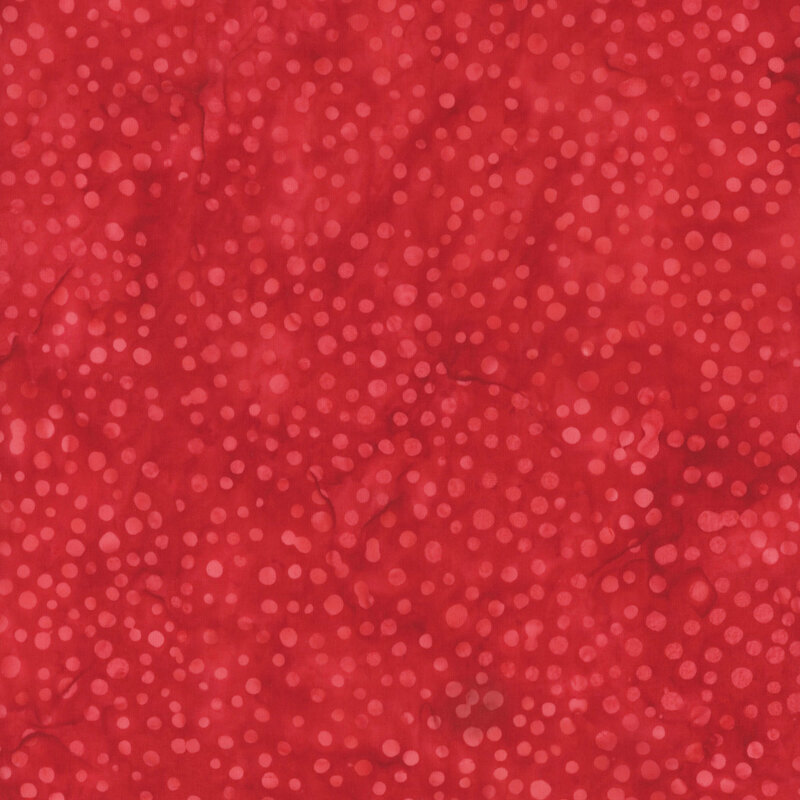 A tonal ruby red batik fabric with dots. 