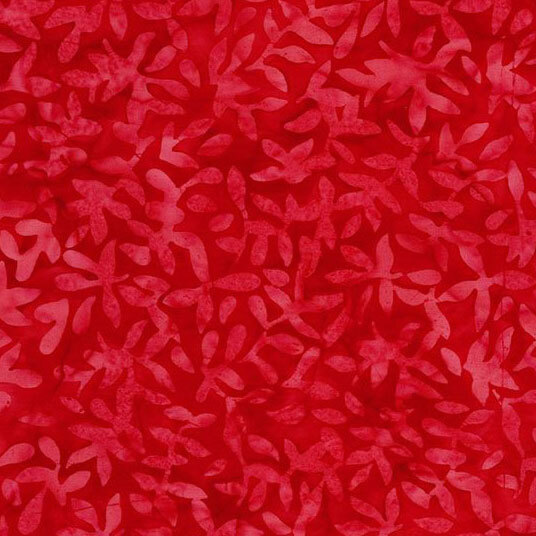 A tonal bright red batik fabric with leaf sprigs.