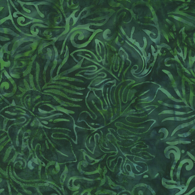 A very green batik fabric with green monstera leaves. 
