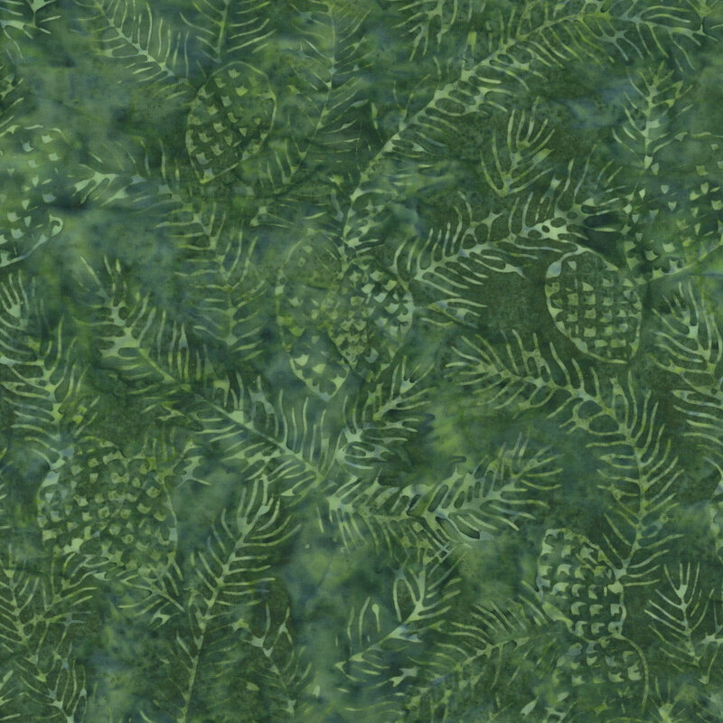 A green batik fabric with green scattered pine branches and pinecones. 