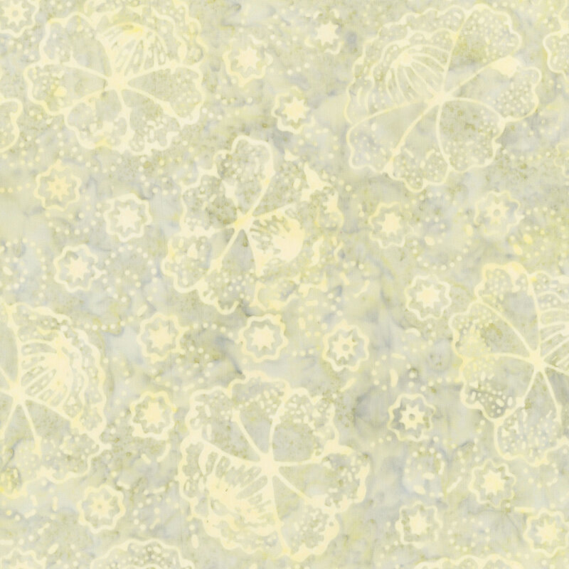 A faded sage green batik fabric with flowers, dotted swirls, and blossoms. 