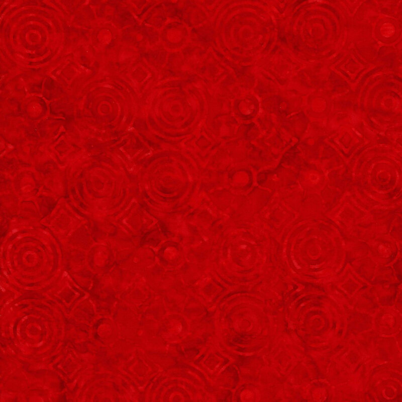 Bright red fabric featuring tonal circles and diamonds in rippling patterns from their centers.